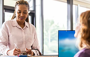 patient with doctor, who is taking notes